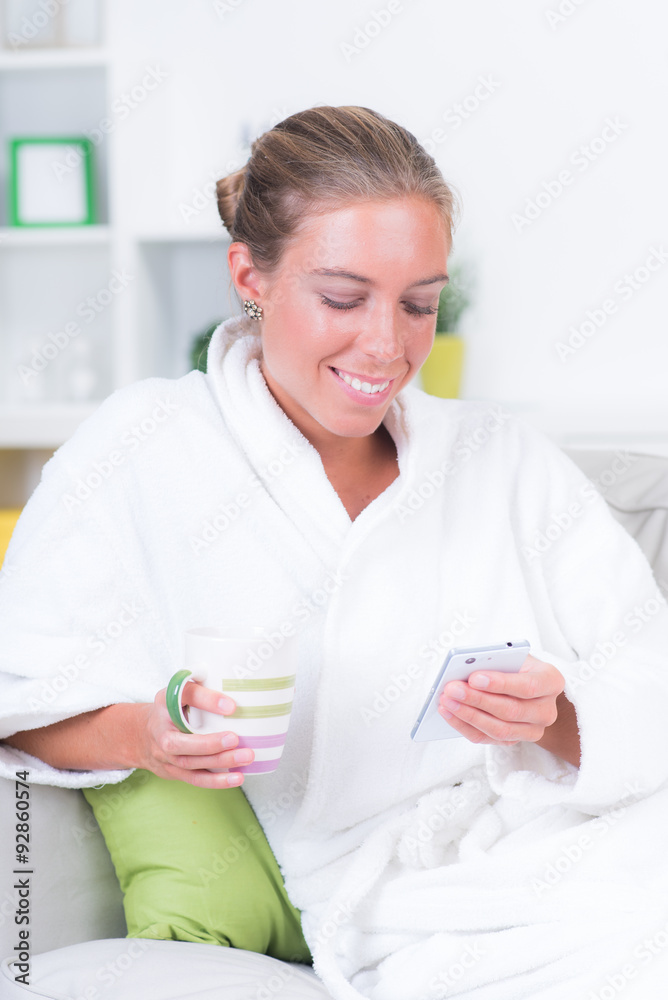 Entspannte Frau schaut auf Ihr Smartphone Entspannte Frau schaut auf Ihr Smartphone