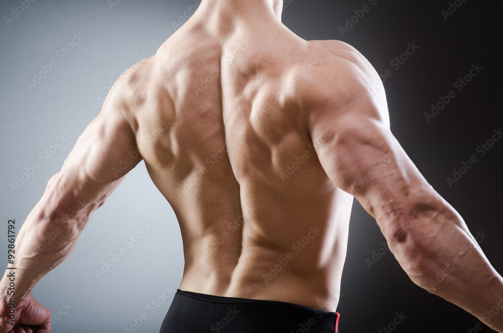 Muscular man posing in dark studio