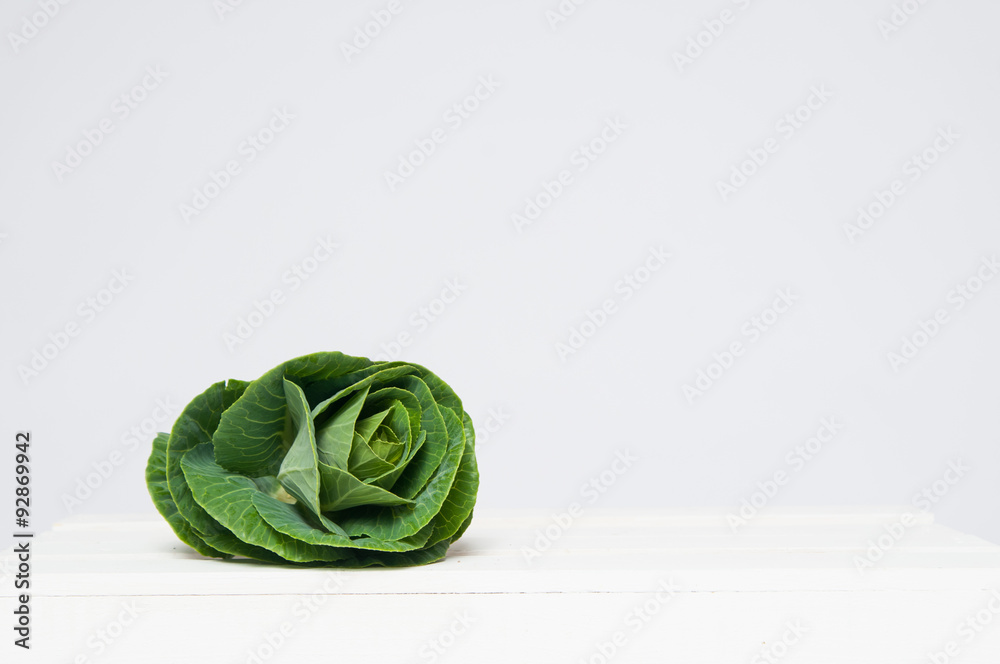 Fototapeta premium fresh green cabbage plant on a white crate