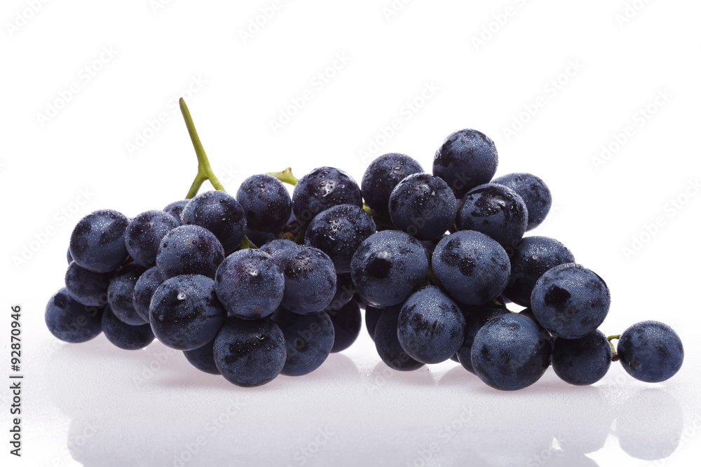 Fresh grape cluster on white with water drops