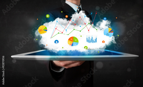 Person holding a touchpad with cloud technology and charts