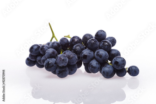 Fresh grape cluster on white with water drops