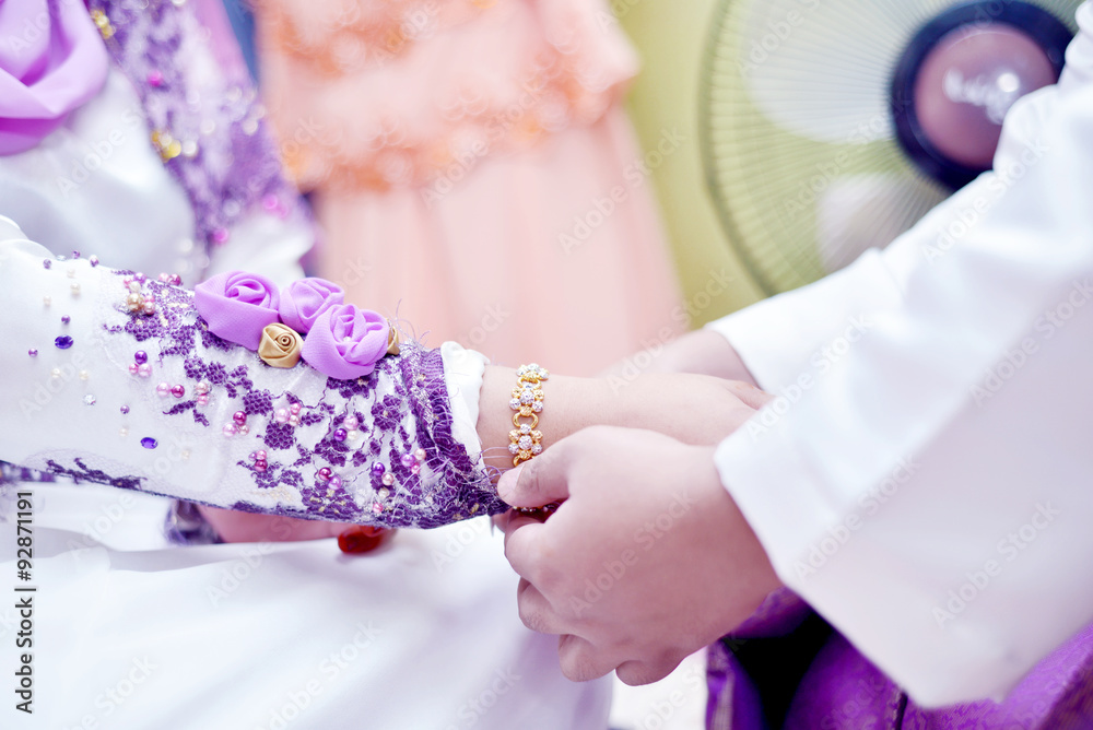 Malay Wedding Couple Putting  A Gold Bracelet On Hand.Selective Focus And Shallow DOF.