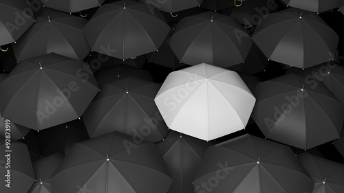 Classic large black umbrellas tops with one white standing out.