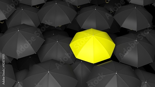 Classic large black umbrellas tops with one yellow standing out.