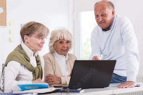 Elderly students sitting beside laptop