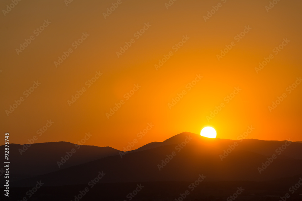 Scenic view of a beautiful rich orange sunset over the mountains