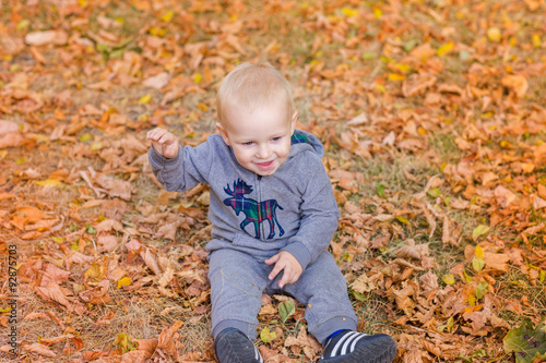 Cute baby in autumn leaves. © len44ik
