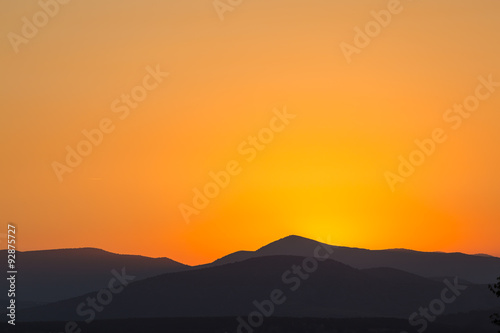 Scenic view of a beautiful rich orange sunset over the mountains