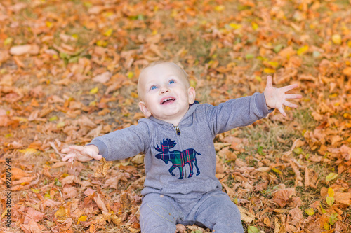 Cute baby in autumn leaves.