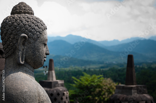 Stone budhha sideview in front of two stupas, Borobudur photo