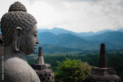 Stone budhha sideview in front of two stupas, Borobudur