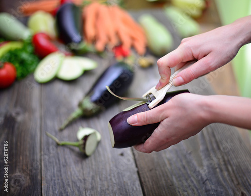 Woman's hand peeling fresh eggplant