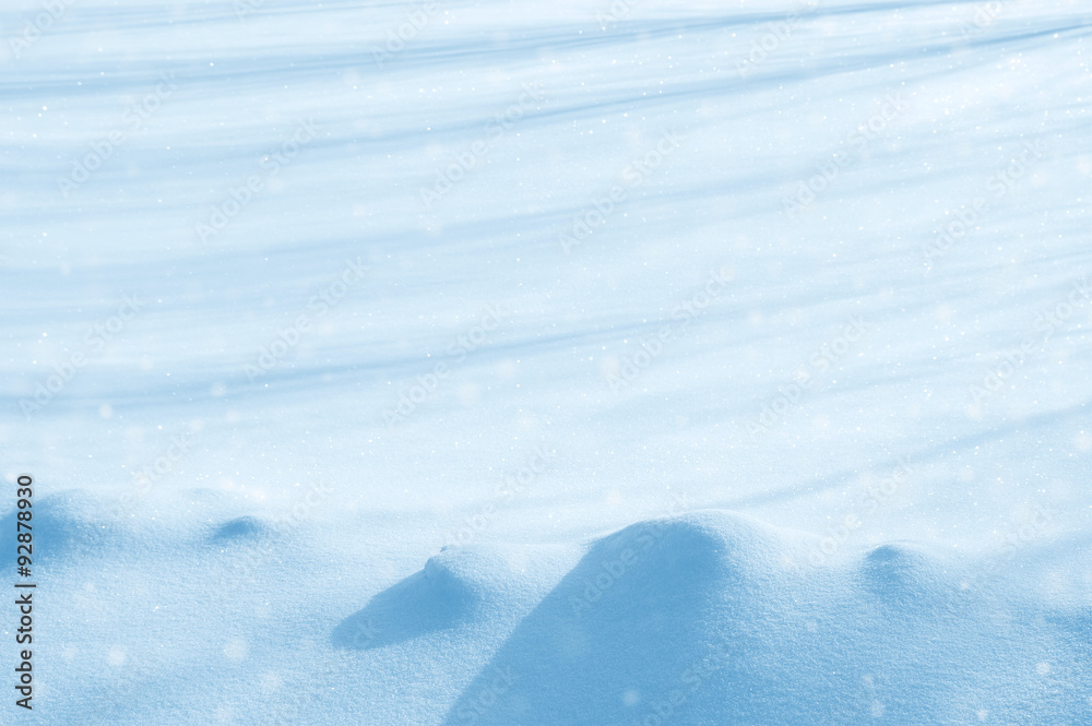 Natural winter background with snow drifts and falling snow