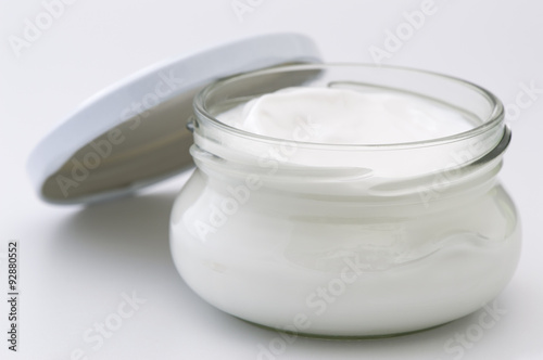 Glass jar with body cream isolated on white background