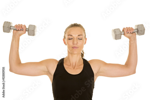 woman fitness black tank top flex with weights eyes closed