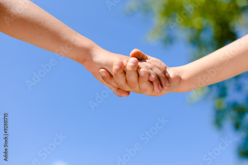 Closeup of two kid's hands holding each other in summertime © gorosi