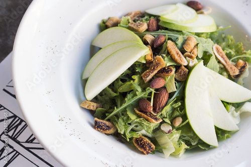 Healthy spinach and arugula salad with cilantro, dried figs, spiced almonds and apple served with a lite vinaigrette.