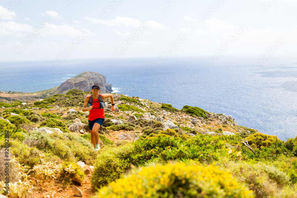 Happy trail running man in inspirational mountains