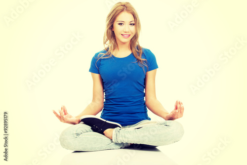 Young woman in lotus yoga pose.