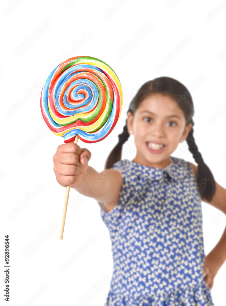 Latin female child holding huge lollipop happy and excited in pony tails candy concept