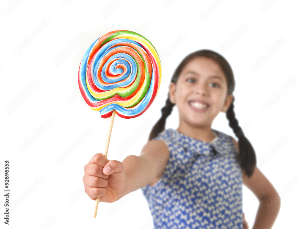 Latin female child holding huge lollipop happy and excited in pony tails candy concept