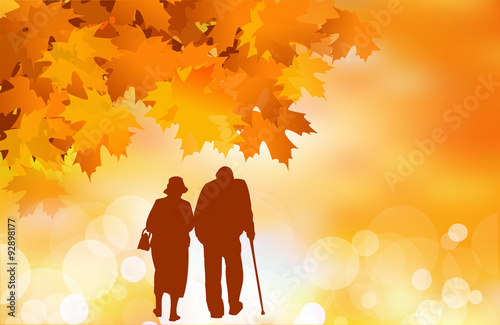 Golden age: senior couple walking, fall leaves background