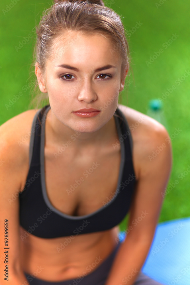 Beautiful young woman relaxing after exerscises on the grass Beautiful young woman relaxing after exerscises on the grass