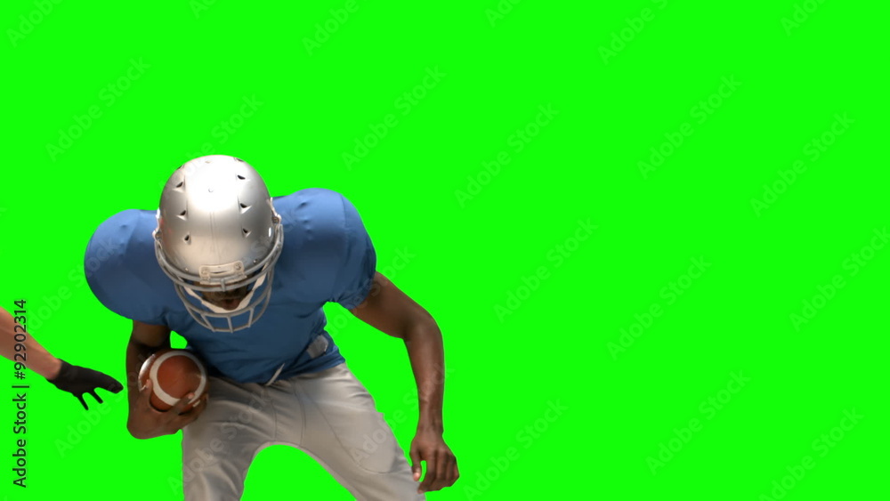 Serious american football player tackling for ball Serious american football player tackling for ball
