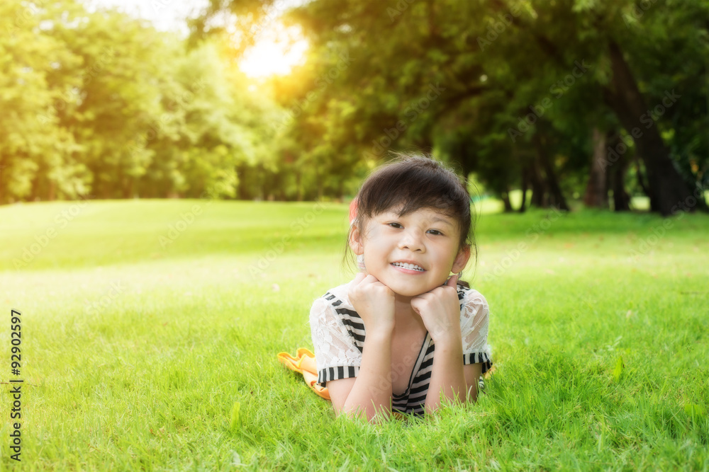 Little asian girl laying down on the green grass Little asian girl laying down on the green grass