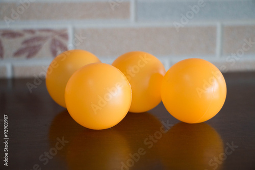 four orange table tennis balls on brown table photo