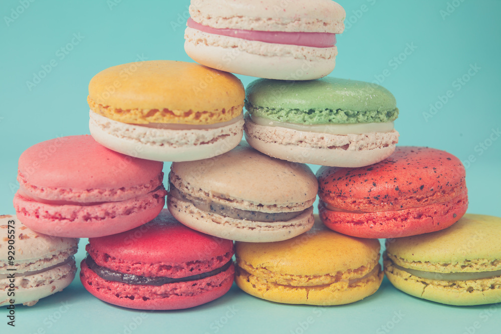 Pile of colorful macaroons stacked up like a tower in blue turquoise pastel isolated background Pile of colorful macaroons stacked up like a tower in blue turquoise pastel isolated background