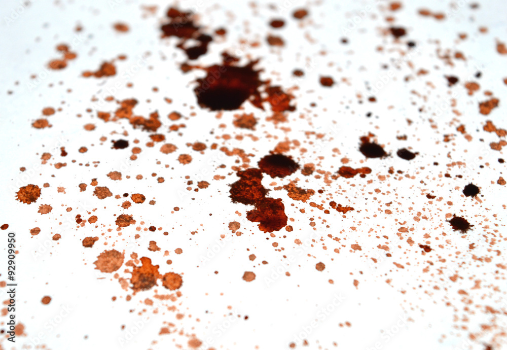 Abstract splashes of coffee or blood on white table surface
