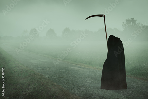 Death with scythe waiting on a misty road
