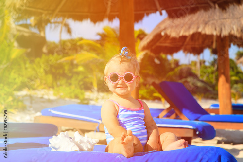 cute little baby girl with seashells on tropical beach