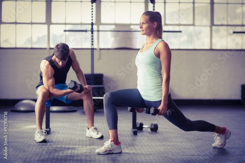 Serious couple exercising with dumbbells 