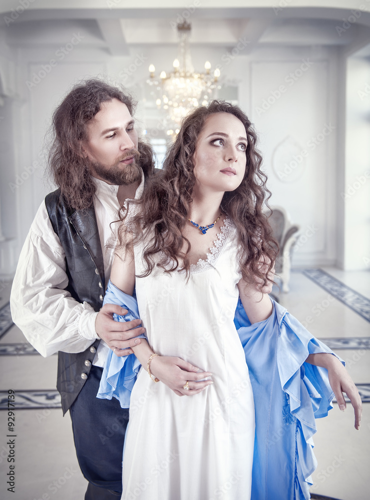 Fototapeta premium Handsome man in medieval costume undress beautiful woman