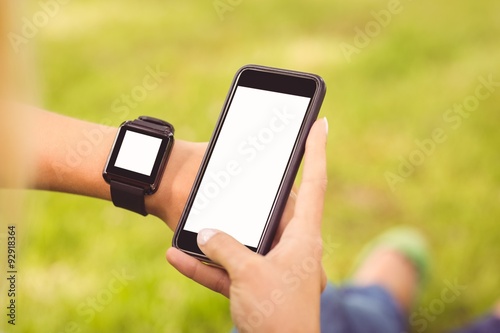 Cropped hands wearing smart watch and holding smartphone 