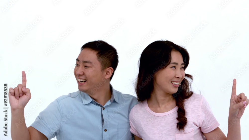 Attractive young couple embracing and pointing