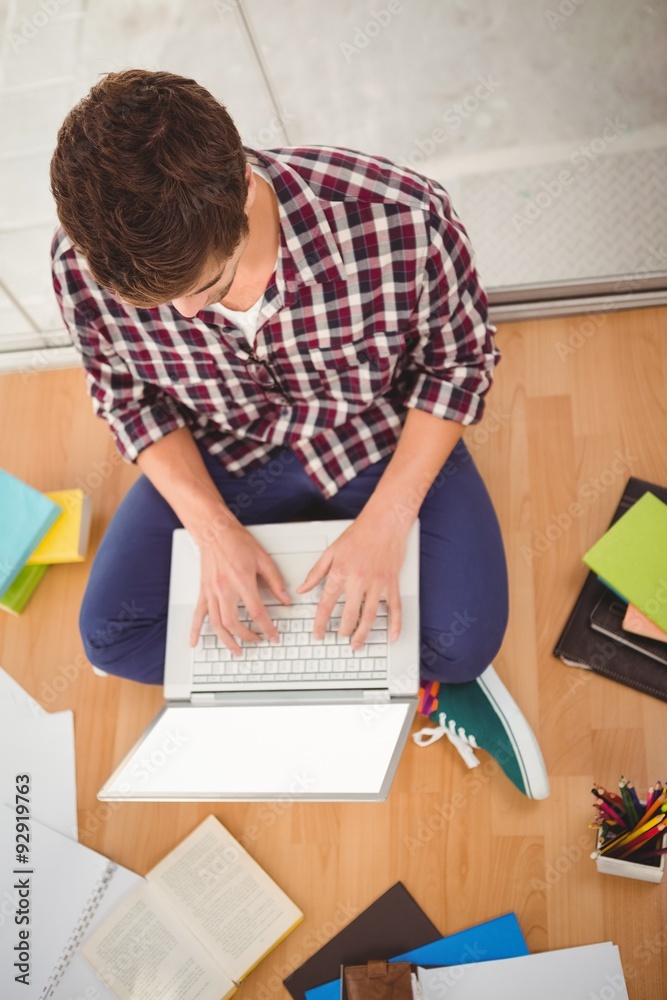 Hipster working on laptop in office Hipster working on laptop in office
