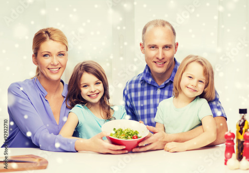 happy family with two kids showing salad in bowl