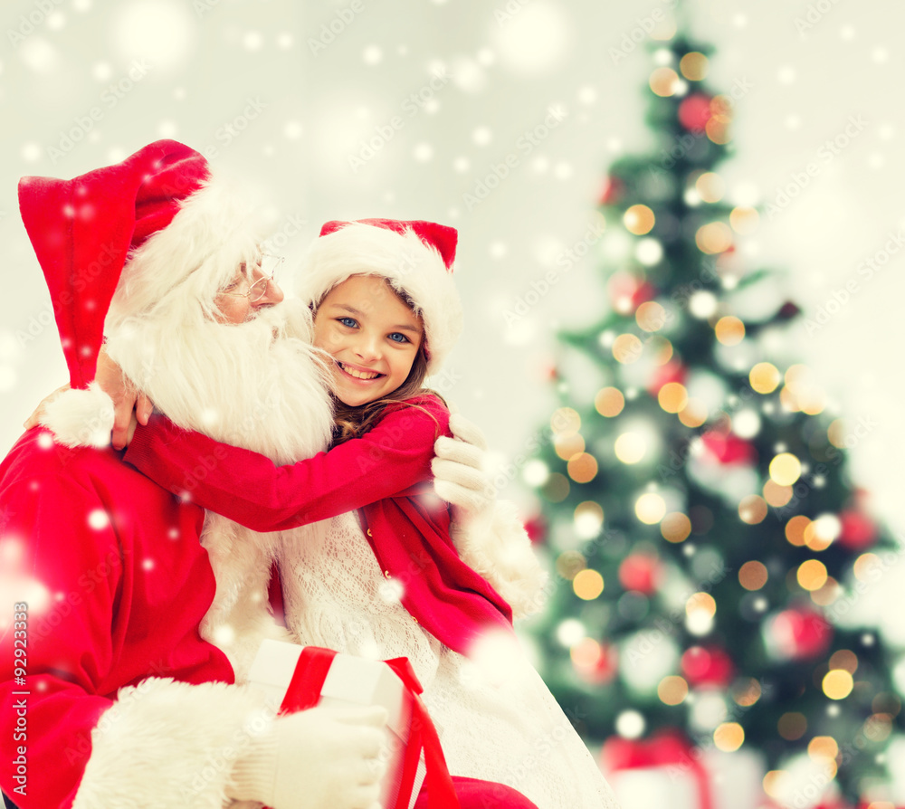 smiling girl with santa claus and gift at home