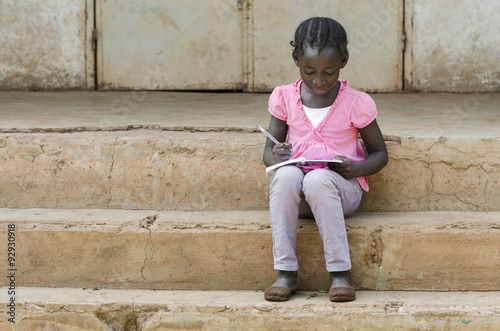 School Symbol: Beautiful black African teenage girl writing her lessons down in a school environment in the public school of Bamako, Mali. © Riccardo Niels Mayer