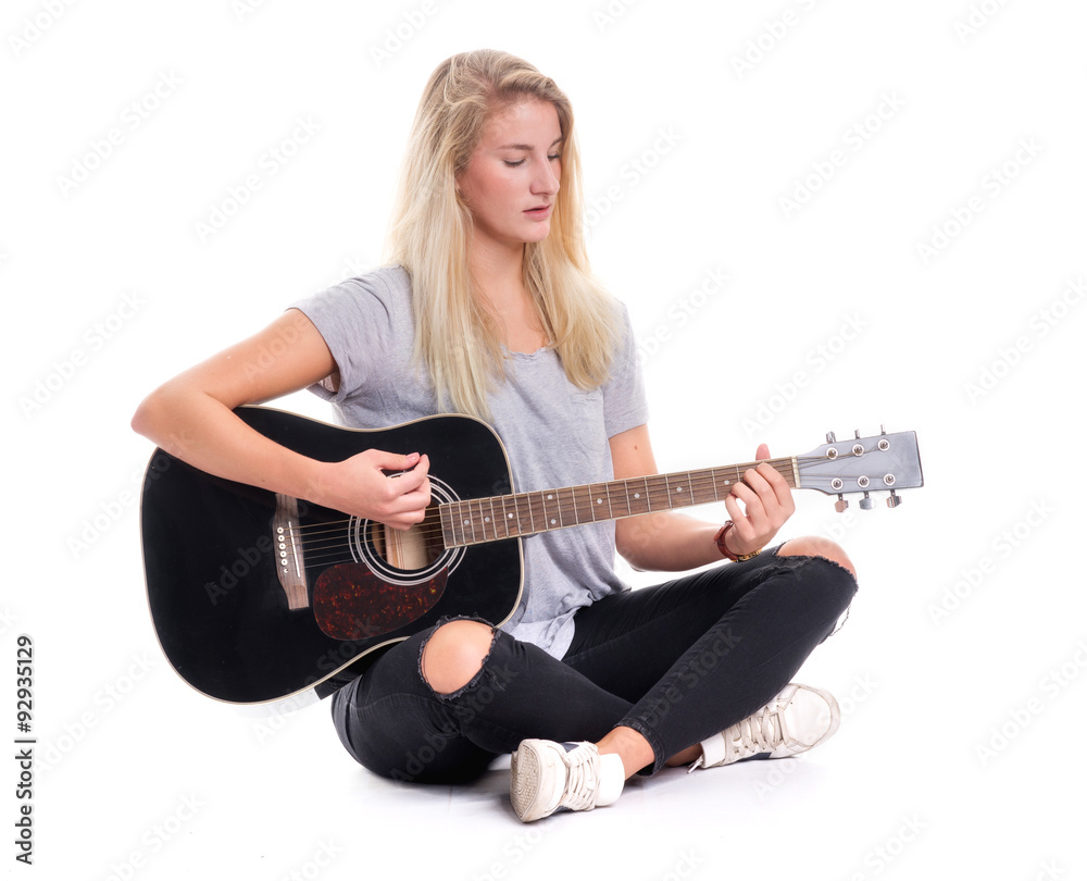Junges Mädchen im Schneidersitz spielt Gitarre Junges Mädchen im Schneidersitz spielt Gitarre