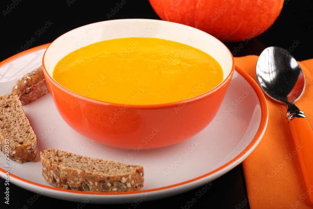 pumpkin hokkaido soup with bread on white plate on black pumpkin hokkaido soup with bread on white plate on black