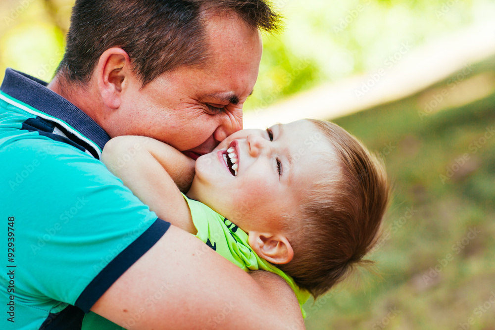 Cheerful father having fun with his little son in the park. Cheerful father having fun with his little son in the park.
