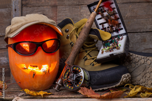 halloween pumpkin with wading boots and fly-fishing photo