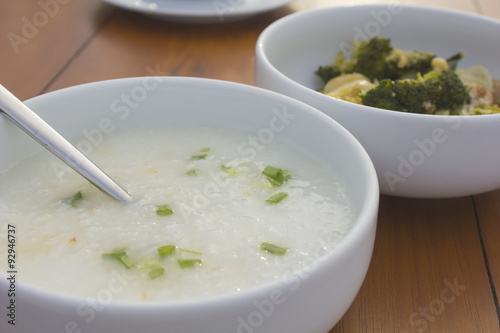 porridge and stir fried vegetable  in white bowl on wooden table