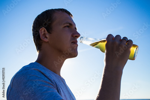 close up portrait of young man drinking beer