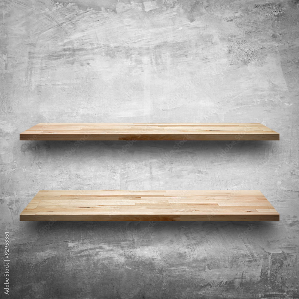 Empty wooden shelves on bare concrete wall background